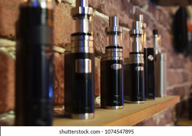 Electronic cigarette on a background of vape shop. E-cigarette for vaping. Popular vape devices