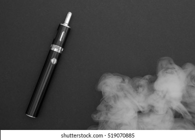 Electronic Cigarette Over A Dark Background. E-cigarette For Vaping. Popular Devices Of The Year - Modern Vaping Device. Stop Smoking,start Vaping Vape