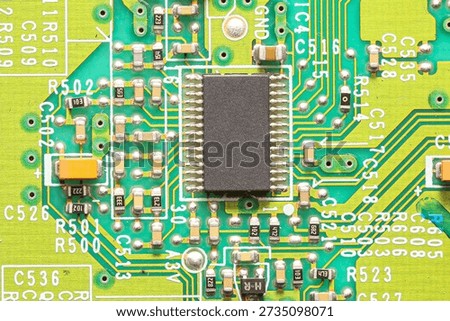 Electronic circuit board with integrated microchip. Printed circuit board closeup. Semiconductor and microcontroller technology background. Green PCB with soldered components and signal paths.