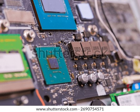Electronic circuit board with microchips, processors, RAM modules, and other components, representing modern technology and computing