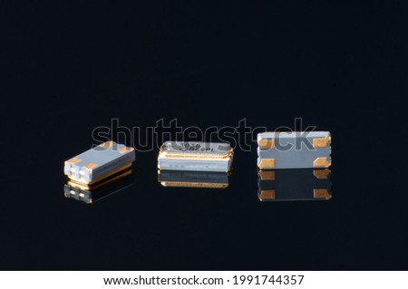 Electronic components close-up. Marco of oscillator crystal on black background.