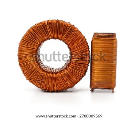 Electronic components consisting of a toroidal copper wire transformer and a vertical induction coil isolated on a white background.