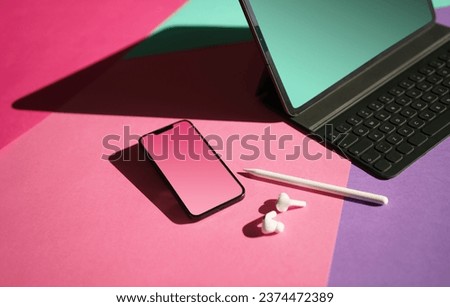 Electronic creative tools. Smart devices. Phone and laptop clean screen mockup. Headphones, graphic tablet pencil. Colorful background.