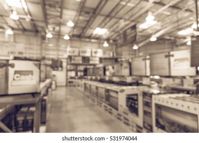 Electronic Department Store With Row Of TVs On Shelves Display. Television Retail Shop, TVs Shelf Wholesale Store. Defocused Warehouse Interior Technology Aisle, Inventory, Export, Business Concept.