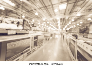 Electronic Department Store And Row Of TVs On Shelves Display. Television Retail Shop, TVs Shelf Wholesale Store. Defocused Warehouse Interior Technology Aisle, Inventory, Export Concept. Vintage Tone