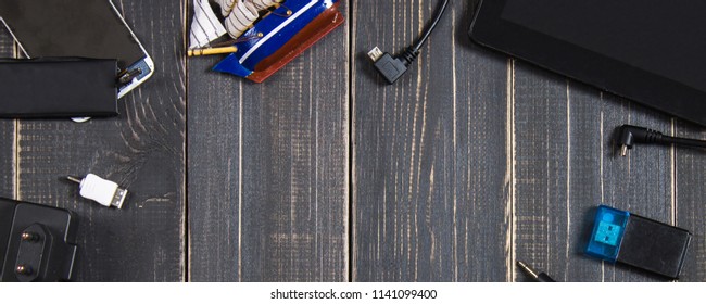 Electronic devices and elements on a dark wooden background. Place for the text. A concept for Father's Day. The programmer's desk. Hobby. Top view. Flat laying.