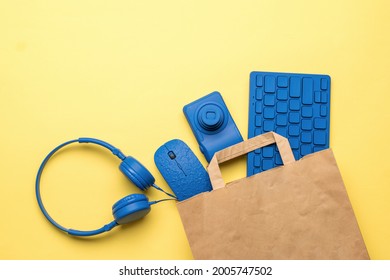 Electronic Devices In A Paper Bag On A Yellow Background. Purchase Items For The Office. Flat Lay.