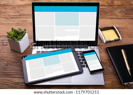 Electronic Devices With Screen On Wooden Desk Near Diary And Pen