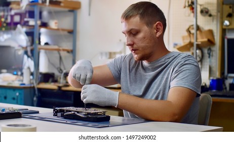 Elektronischer Ingenieur für Computertechnik bei der Arbeit. Reparateur repariert Grafikkartenchipsatz in der Werkstatt. Er löst die Schrauben auf dem Tisch. PC-Reparaturtechniker und elektronische Geräte.