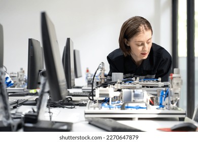 Electronic engineer examining computer equipment in laboratory. Female technician working in the high technology factory repairing electrical components. Maintenance engineering expert in industry 4.0 - Powered by Shutterstock