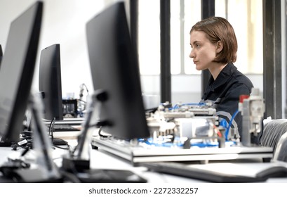 Electronic engineer examining computer equipment in laboratory. Female technician working in the high technology factory repairing electrical components. Maintenance engineering expert in industry 4.0 - Powered by Shutterstock