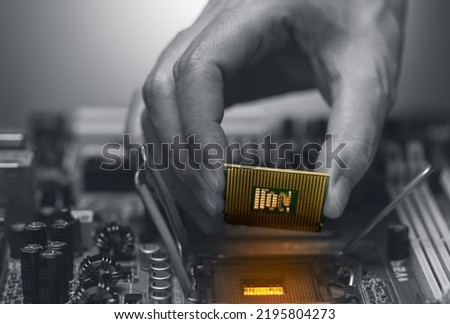 Electronic engineer hand putting computer chip on socket. Chipset on electronic circuit board of PC mother board. CPU chip. Electronic components. Computer hardware. Upgrade computer processor chip.