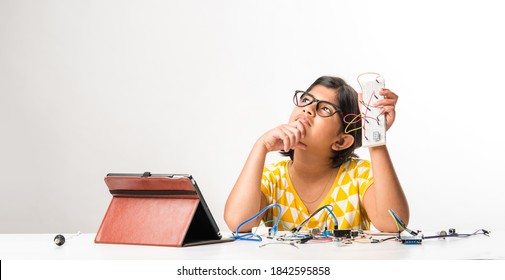 Electronic Experiment - Asian Indian Small Girl Student Performing Or Studying Science With Wires, Connections, Studying From Laptop Or Tablet Computer