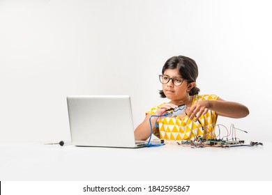 Electronic Experiment - Asian Indian Small Girl Student Performing Or Studying Science With Wires, Connections, Studying From Laptop Or Tablet Computer