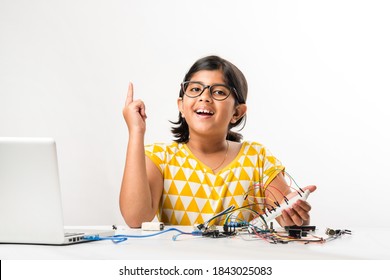 Electronic Experiment - Asian Indian Small Girl Student Performing Or Studying Science With Wires, Connections, Studying From Laptop Or Tablet Computer