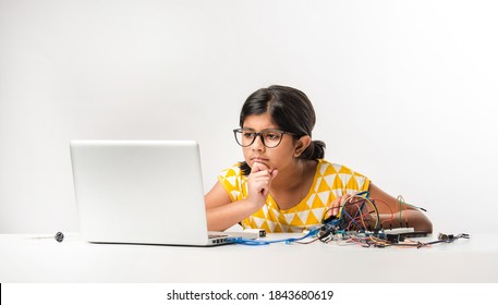 Electronic Experiment - Asian Indian Small Girl Student Performing Or Studying Science With Wires, Connections, Studying From Laptop Or Tablet Computer