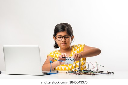 Electronic Experiment - Asian Indian Small Girl Student Performing Or Studying Science With Wires, Connections, Studying From Laptop Or Tablet Computer