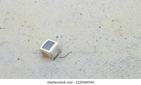 Electronic garbage, CRT or cathode ray tube monitor on the left on the beach. 