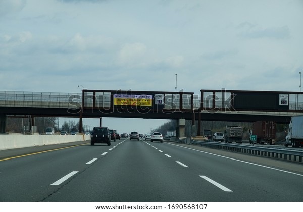 Electronic\
information sign over a busy multi-lane highway that says to move\
over and slow down for emergency\
vehicles