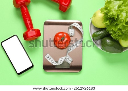 Electronic kitchen scale, measuring tape, dumbbells, smartphone and products on light green background, flat lay. Diet