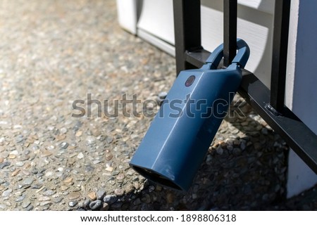 An electronic lockbox activated by a remote code is attached to a home's iron railing.