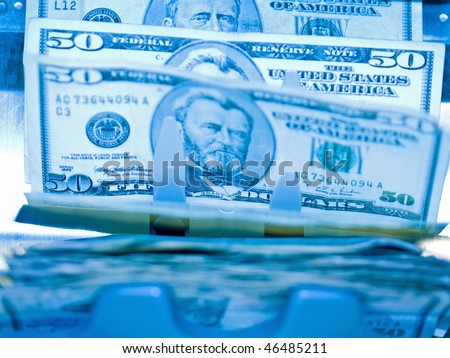 An electronic money counter processing US $50 bills