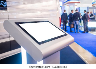 Electronic multimedia kiosk with blank white display at exhibition, trade show, conference - close up view. Mock up, futuristic, corporate, copyspace, template, white screen, technology concept