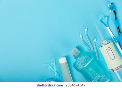 Electronic oral irrigator, toothbrush, paste, dental floss and mouthwash on a blue background. Dental tool for oral hygiene. Electric Interdental Cleaner. Dental water shower. Oral care concept.  - Powered by Shutterstock