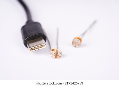 Electronic Parts Photoresistor And USB Cable Connector C On The White Background.