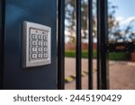 An electronic security system keypad on a building front gate protecting the property with individual security codes at the entrance