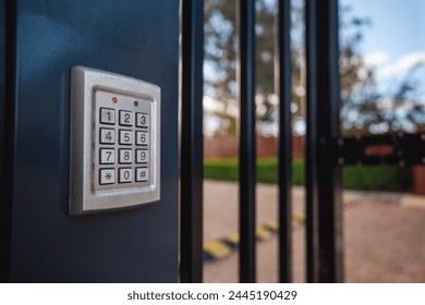 An electronic security system keypad on a building front gate protecting the property with individual security codes at the entrance