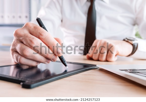 Electronic signature, businessman providing\
e-signature for document agreement using stylus and pad in office,\
selective focus