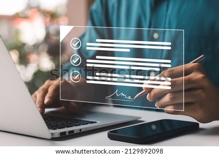 Electronic Signature Concept, Electronic Signing Businessman signs electronic documents on digital documents on virtual laptop screen using stylus pen.