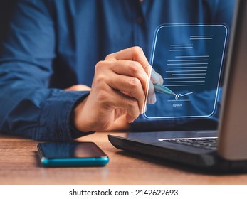 Electronic signature and paperless office concept. A businessman uses a pen to sign electronic documents on digital documents on a virtual screen. E-signing. Technology and document management - Shutterstock ID 2142622693