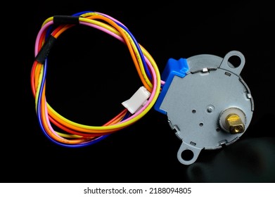 Electronic stepper motor with colorful wires on a black background. Macro photo. Background picture.