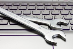 Electronic Technical Support Concept - Spanners On Computer Keyboard