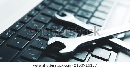 Electronic technical support concept. Wrenches on a computer keyboard.