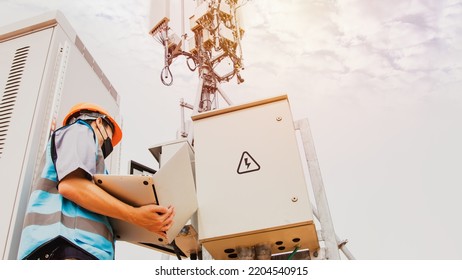 Electronic technician worker man wearing mask, skilled control system, control cabinet, station, signal tower. Telecom uses a laptop to check the telecommunication circuit board system.
 - Powered by Shutterstock