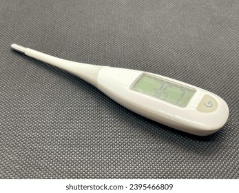 The electronic thermometer shows a normal temperature of 36.7 - Shutterstock ID 2395466809