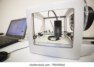 Electronic three dimensional plastic printer during work in laboratory, 3D printer, 3D printing concept. Printing cylindrical component.