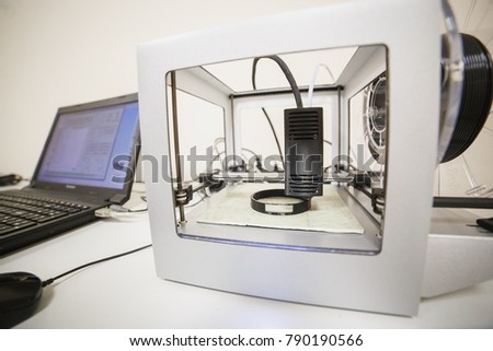 Electronic three dimensional plastic printer during work in laboratory, 3D printer, 3D printing concept. Printing cylindrical component.