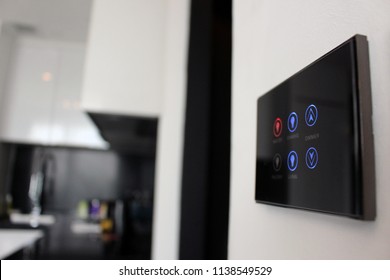 Electronic Touch Screen Light And Temperature Control Panel Wall Mounted In A Modern Apartment Room.