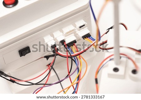 Electronic wiring and cable connectors inside homemade automation device. DIY robotics prototype built with 3D print technology. Technical engineering project with colorful wires and modules.