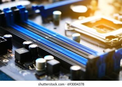 Electronics components on modern PC computer motherboard with RAM connector slot, close-up of electronic, black devices electronic background, Orange Flare