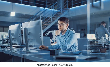 Electronics Development Engineer Sitting At His Desk Uses Personal Computer For Programming. Team Of Professionals Use Digital Whiteboard With CAD Software For The Modern Industrial Engineering Design