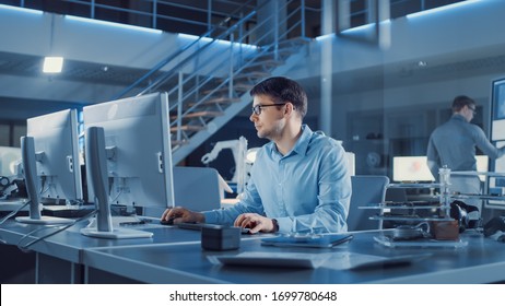 Electronics Development Engineer Sitting At His Desk Uses Personal Computer For Programming. Team Of Professionals Use Digital Whiteboard With CAD Software For The Modern Industrial Engineering Design