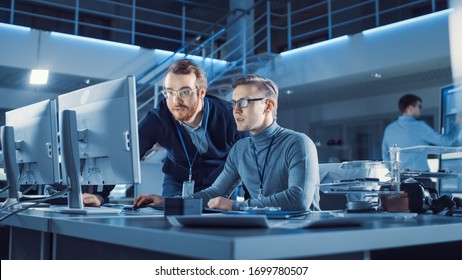 Electronics Development Engineer Uses Personal Computer Talks with Manager, Shows Project. Team of Professionals Use Digital Whiteboard use CAD Software for the Modern Industrial Engineering Design - Powered by Shutterstock