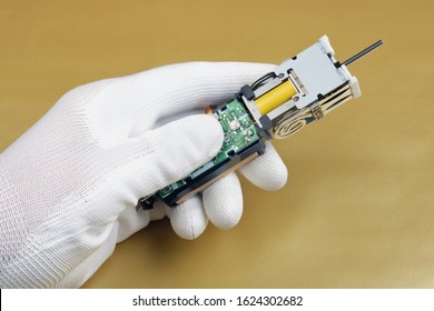 An Electronics Engineer Hold In Hand And Checks And Adjusts A Medical Mass Production  Ultrasound Device