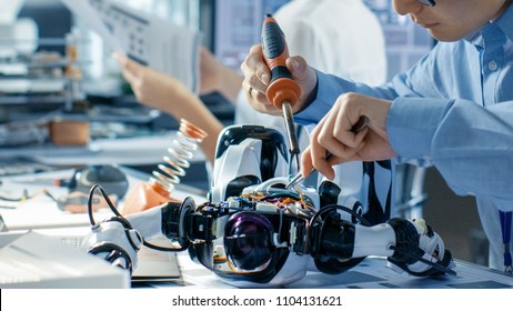 Electronics Engineer Works With Robot, Soldering Wires And Circuits. Computer Science Research Laboratory With Specialists Working.