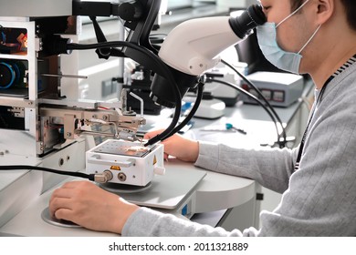 Electronics Engineering Scientist  Working With Microscope Looking At Silicon Micro Chip. Chemicals Researcher Investigating Micro Chip. Semiconductor Technological Manufacturing Process Control